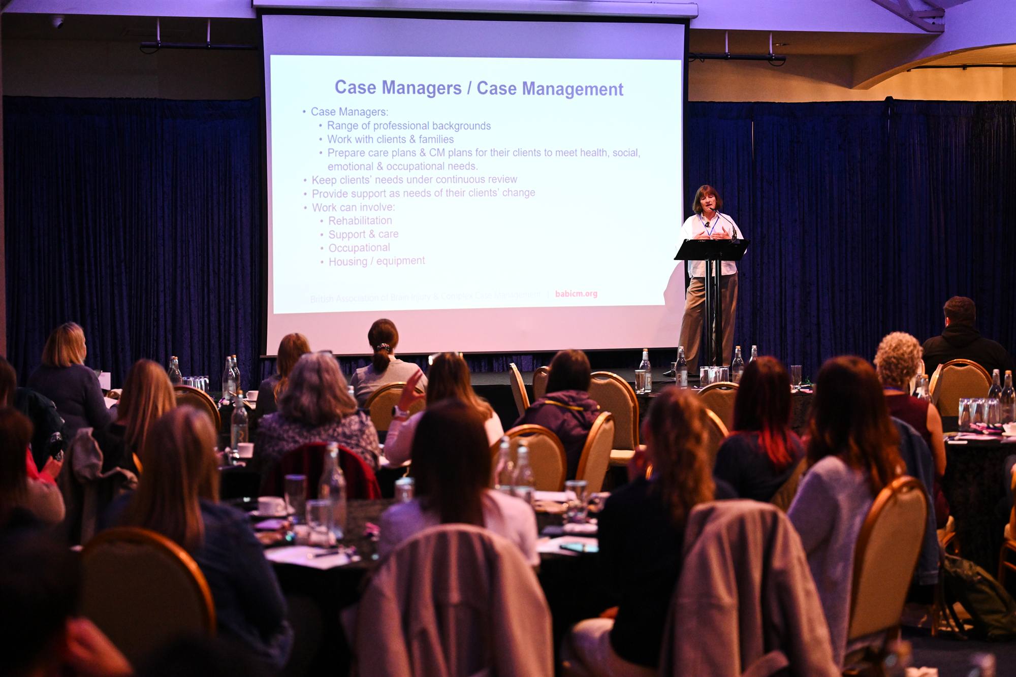 A speaker presenting to a full room of seated delegates at CareConnect 2026.